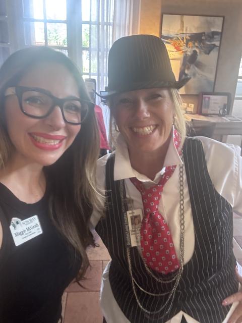 Two members dressed for the 1920s theme in a fedora and pearls
