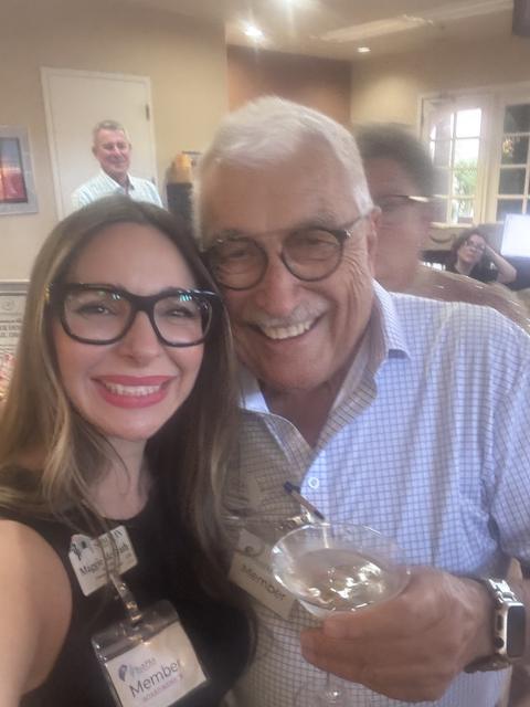 A member and guest share a smile, drinks in hand