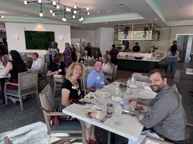 Members seated at round tables for the lunch meeting
