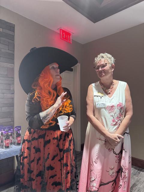 Members in Halloween costumes, witch's hat included