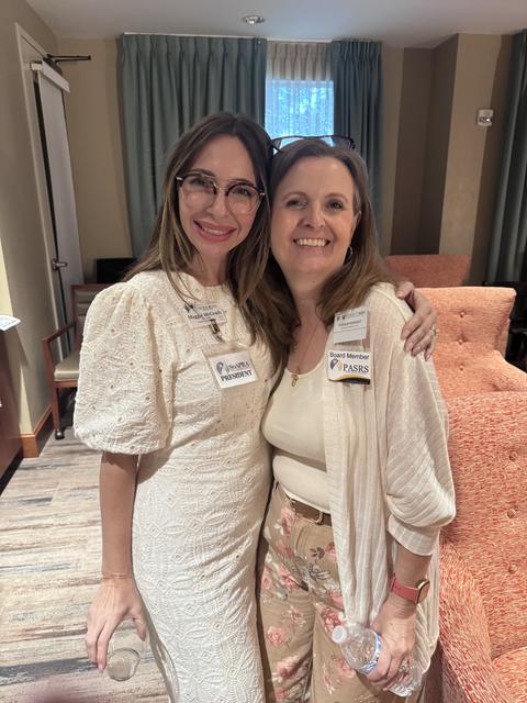 Two members smile together at the October meeting